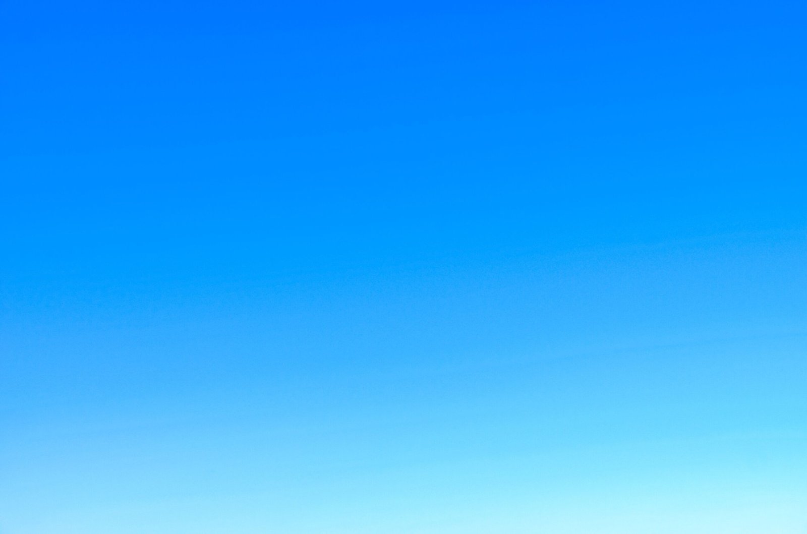 A serene view of a vibrant clear blue sky with a subtle gradient, perfect for backgrounds.